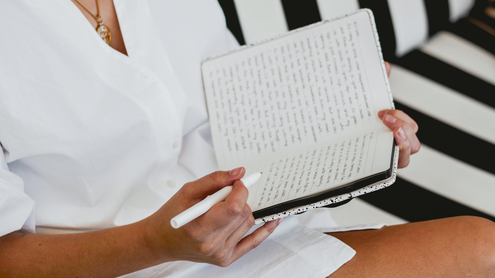 a person holding a pen and a notebook