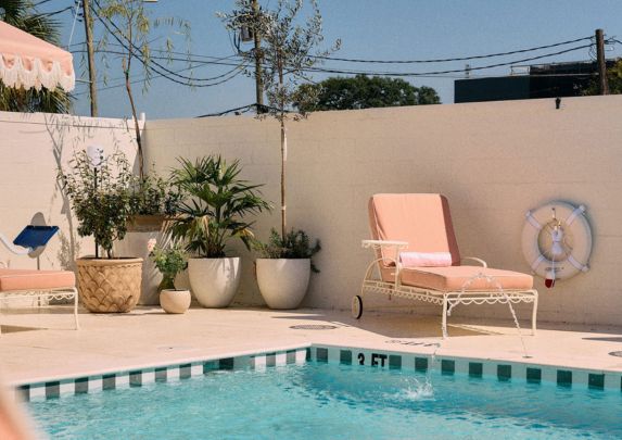a pool with a chair and plants