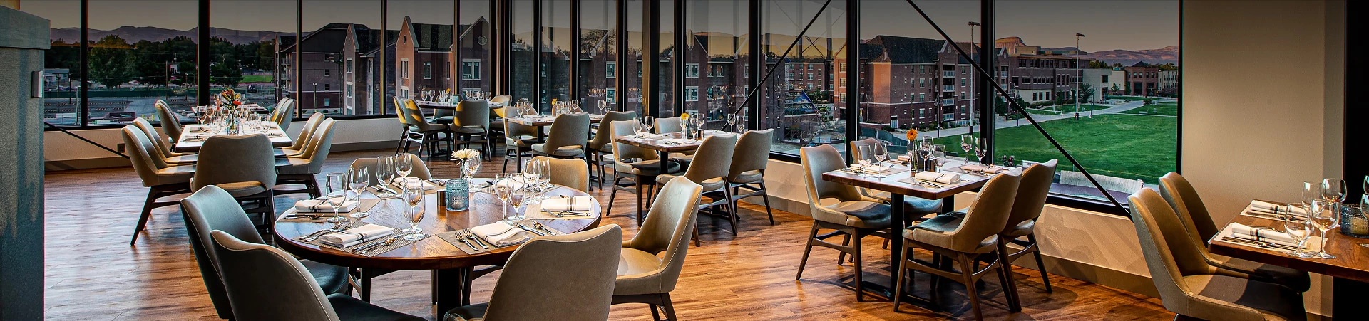 dining tables in room with floor to ceiling windows