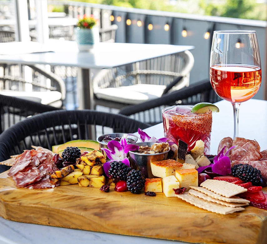 a glass of wine next to a plate of food and a glass of wine