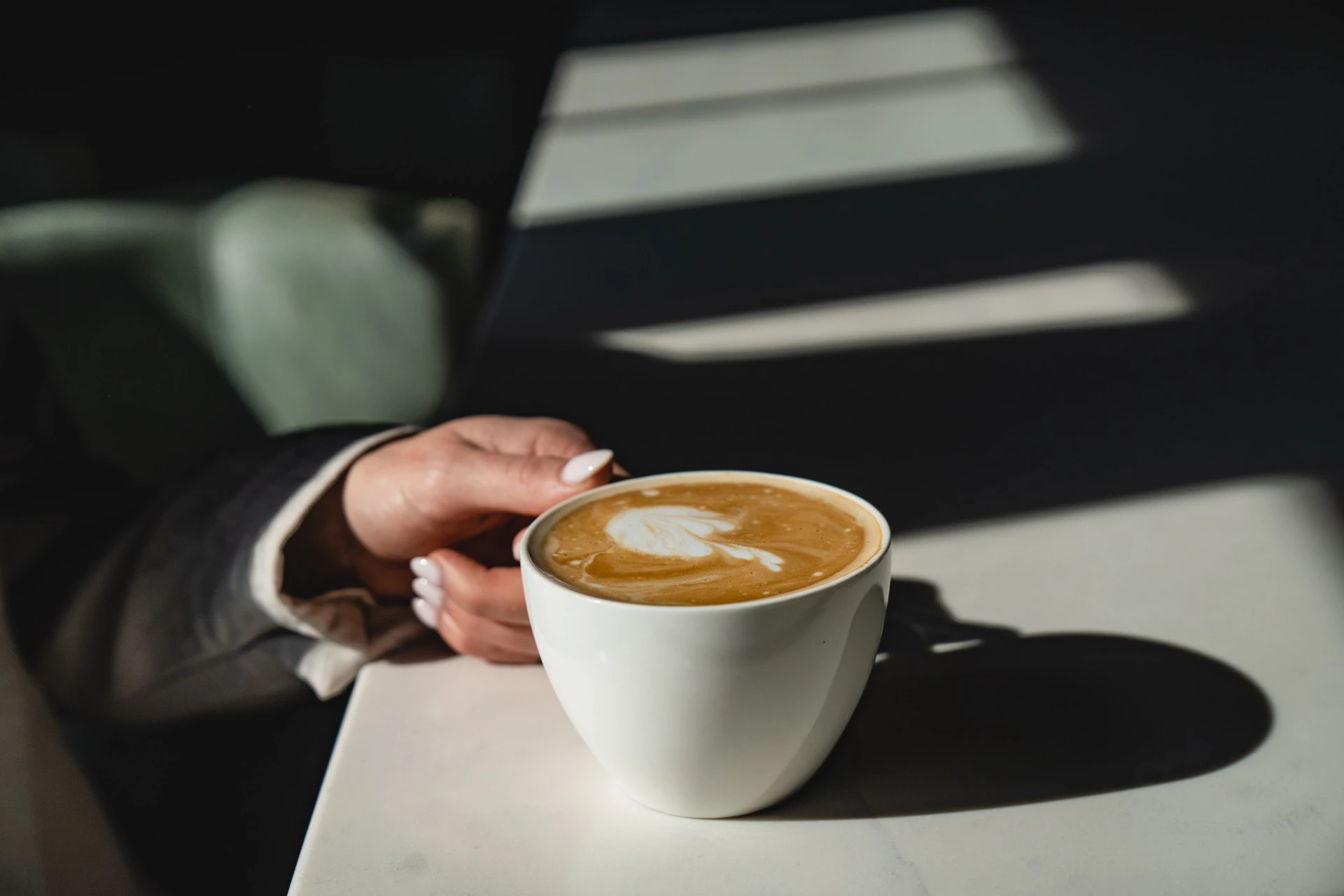 a hand holding a cup of coffee