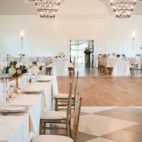 a room with tables and chairs and chandeliers