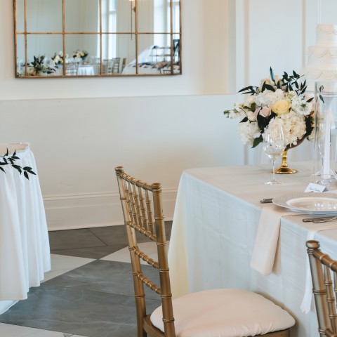 a table with white tablecloths and chairs