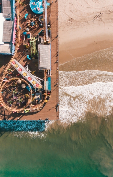 a pier with a roller coaster and a beach