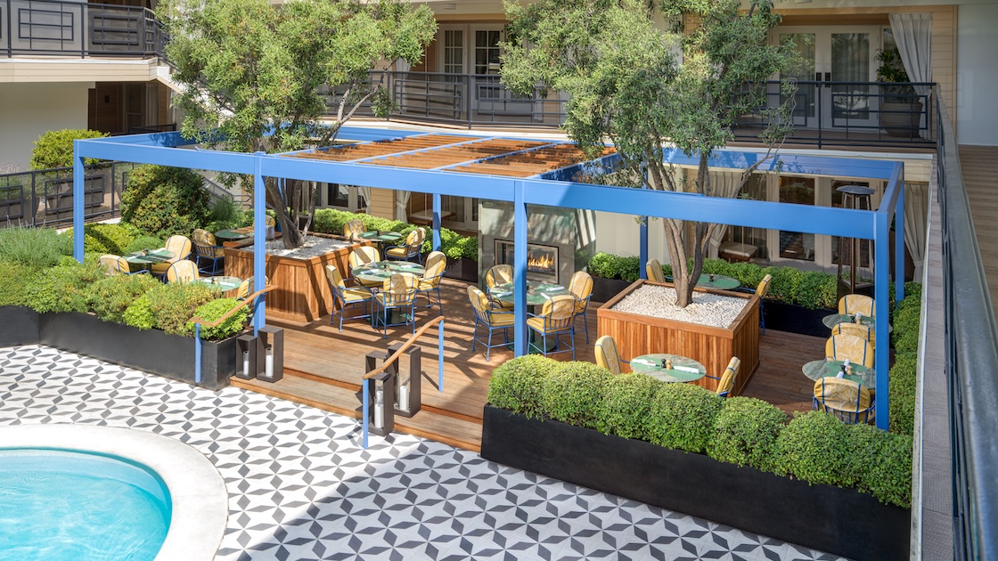 a patio with tables and chairs and trees
