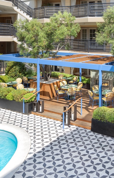 a patio with tables and chairs and a pool