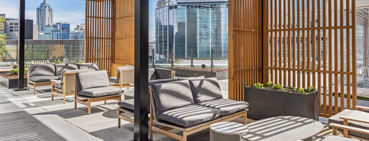 a couches and chairs outside with a glass wall