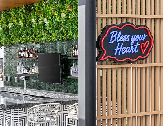 a bar with a sign and shelves of liquor