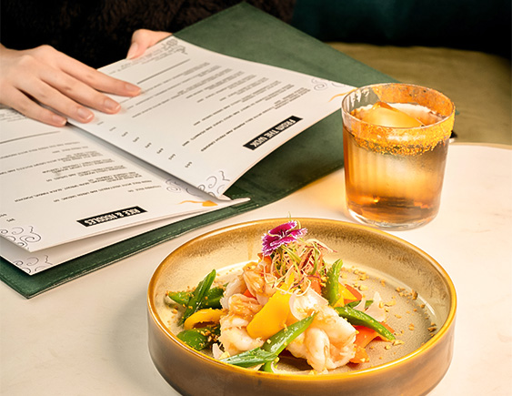 a plate of food and a glass of liquid next to a book