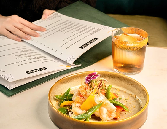 a plate of food and a glass of liquid next to a book