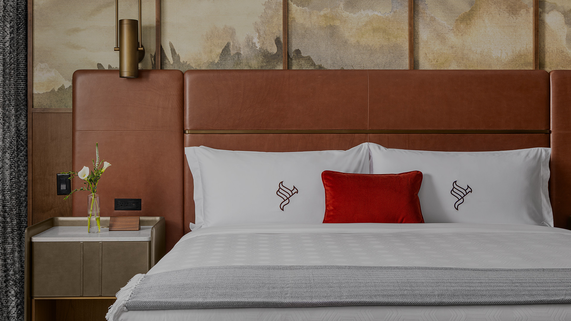 a bed with a red pillow and a lamp