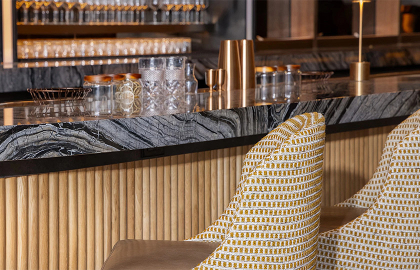 a bar with chairs and glasses