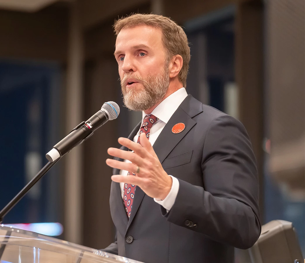 a man in a suit speaking into a microphone