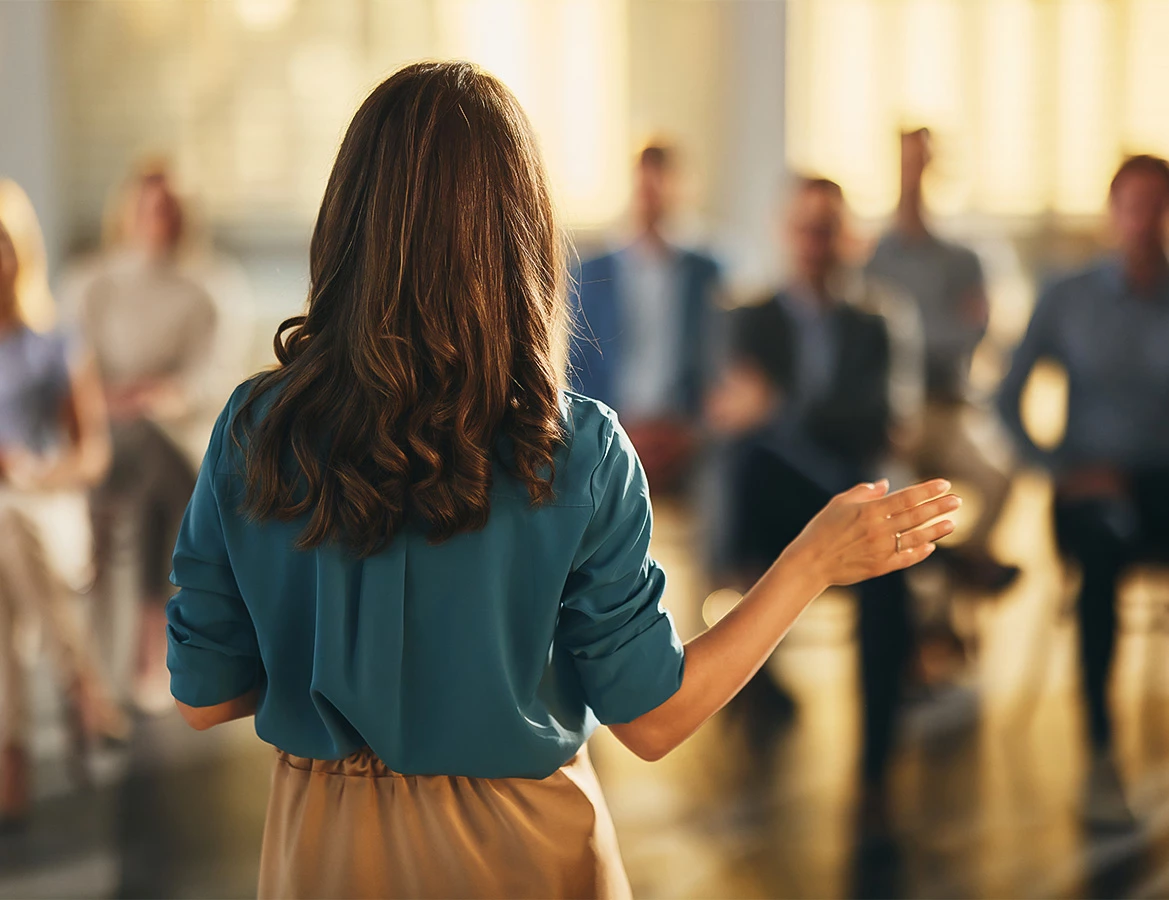 a woman standing in front of a group of people
