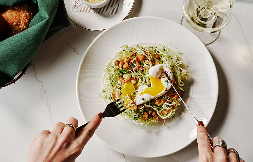 a person holding a fork over a plate of food