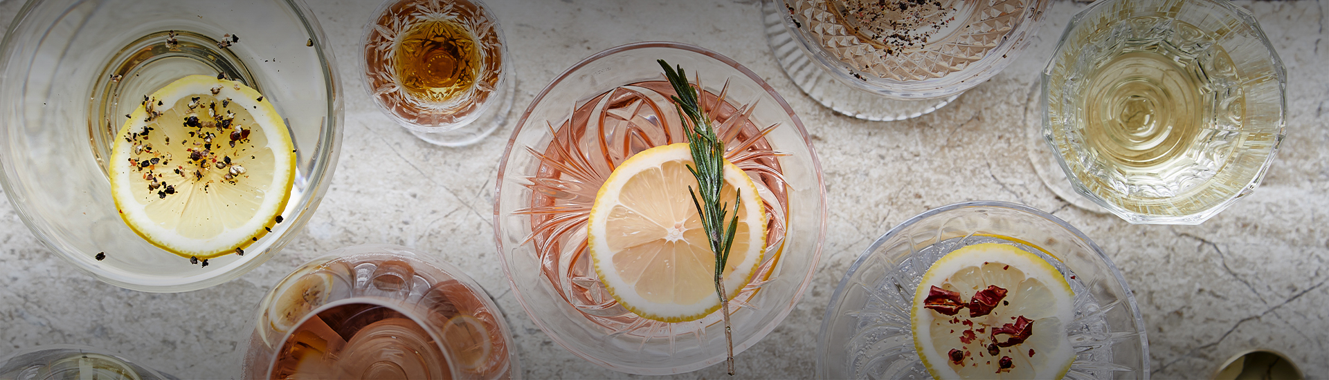 a glass with a lemon slice and a sprig of rosemary