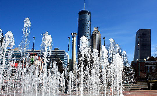 a water fountain in front of a city