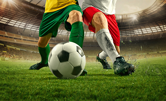 two football players kicking a football ball