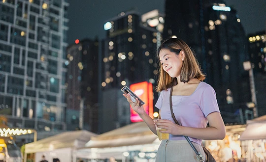 a woman holding a phone and a drink