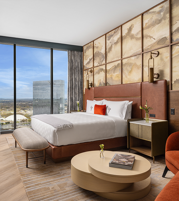 a bedroom with a large window overlooking a city