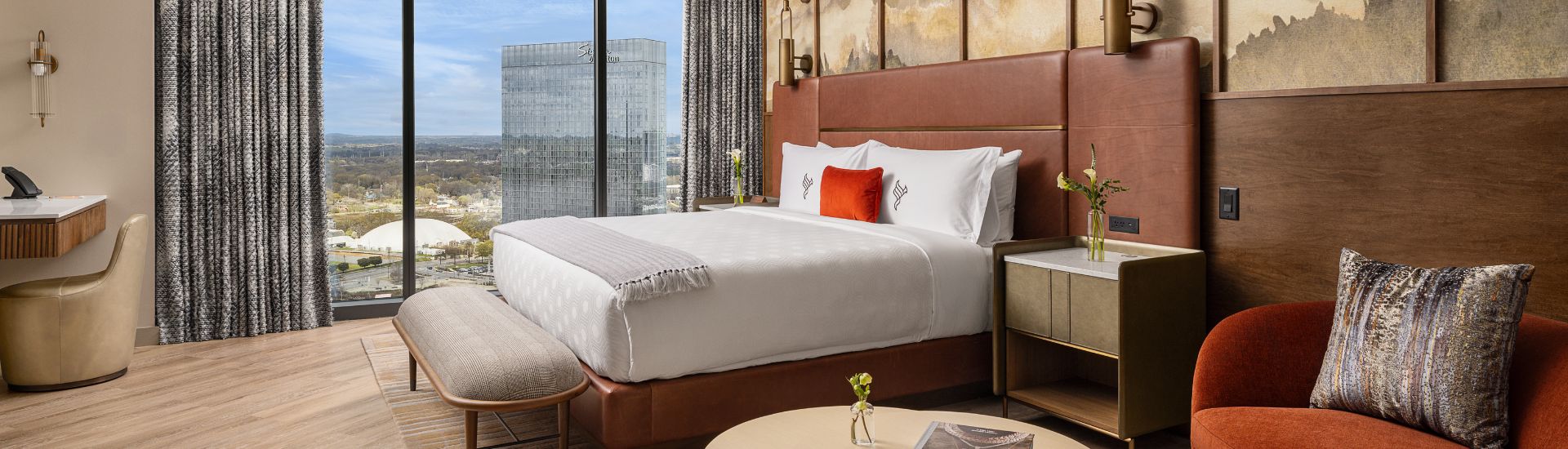 a bed with a brown headboard and a table with a window