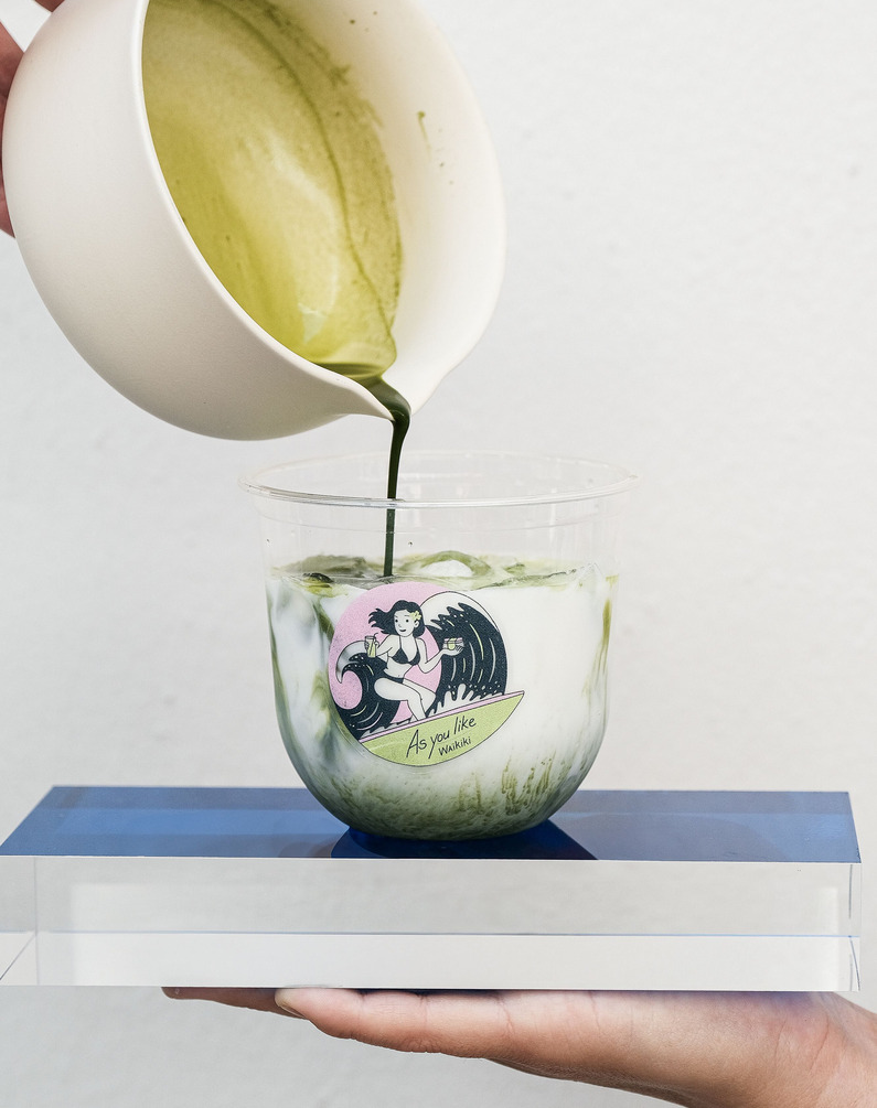 a person pouring green liquid into a cup