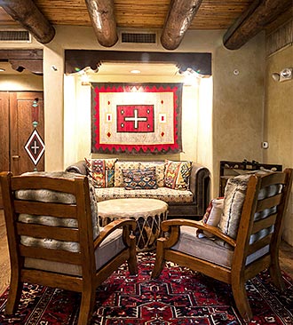 Sitting area with a couch, two chairs, and a table and Native American inspired decor