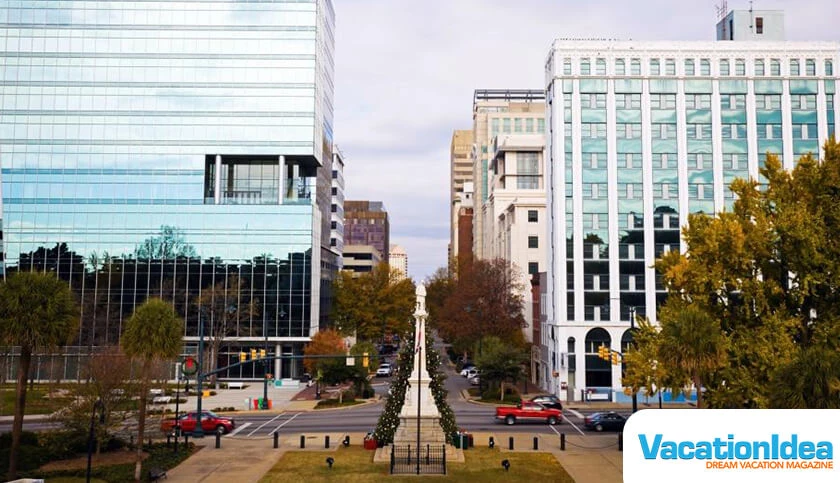 a city street with buildings and a monument