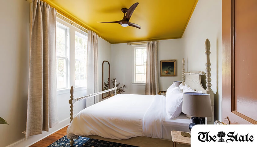 a room with a yellow ceiling and a bed