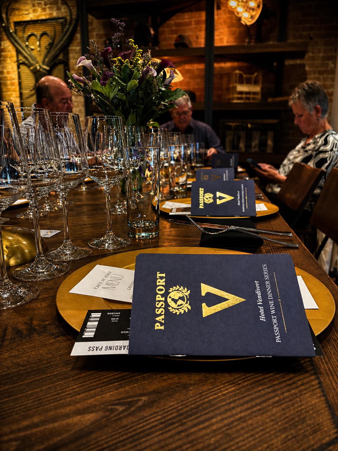 a group of people sitting at a table with glasses and passport