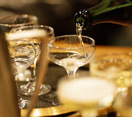 a person pouring liquid into a glass