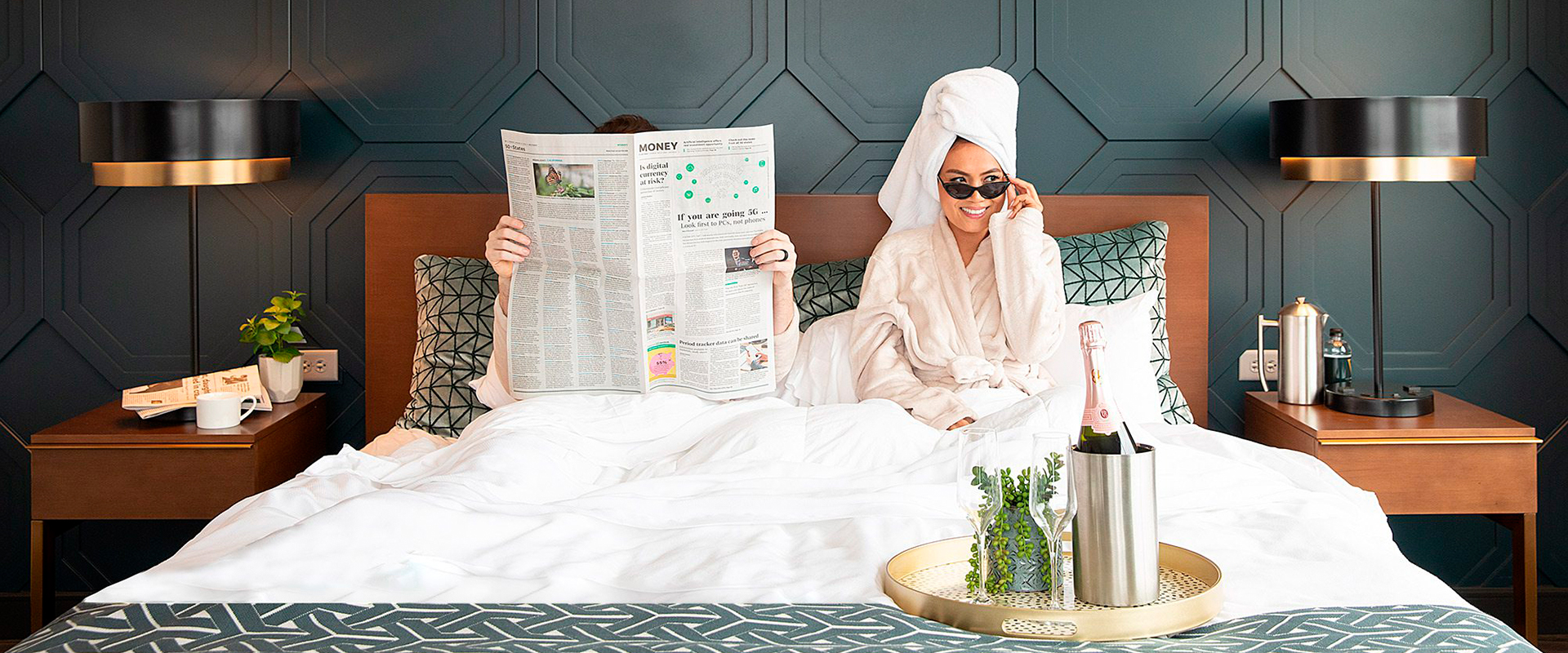 a woman in a bathrobe reading a newspaper in bed