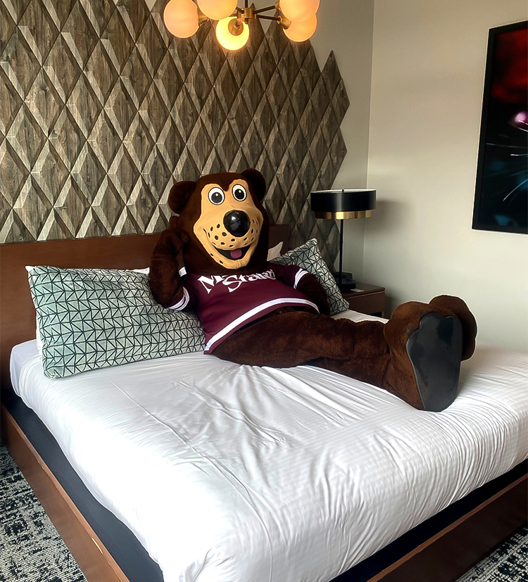a person wearing a mascot garment lying on a bed