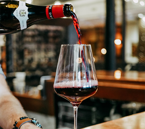 a person pouring wine into a glass