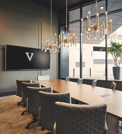 a conference room with a chandelier and chairs