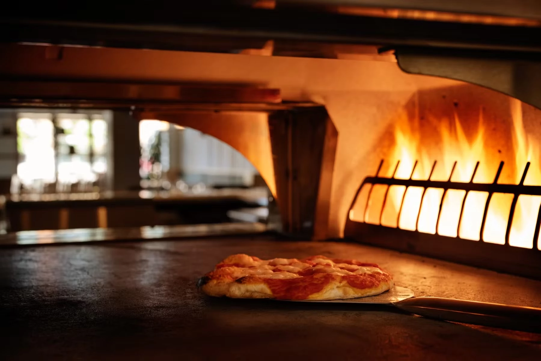 a pizza cooking in a wood fired oven