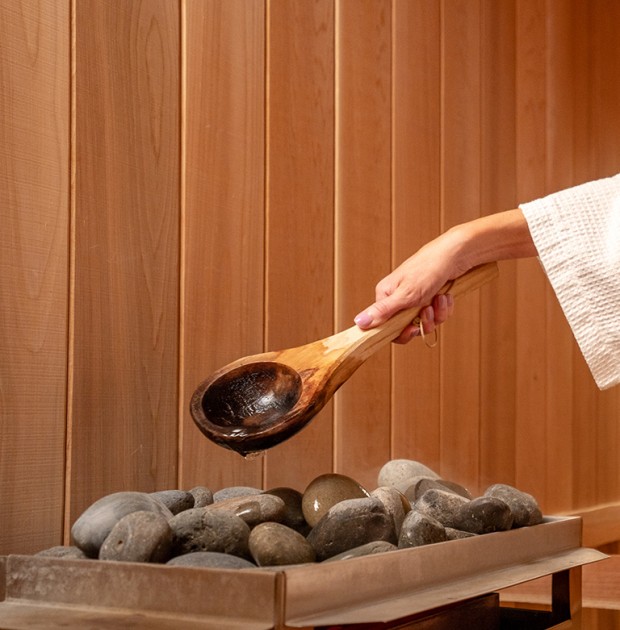 a person pouring water into a wooden spoon