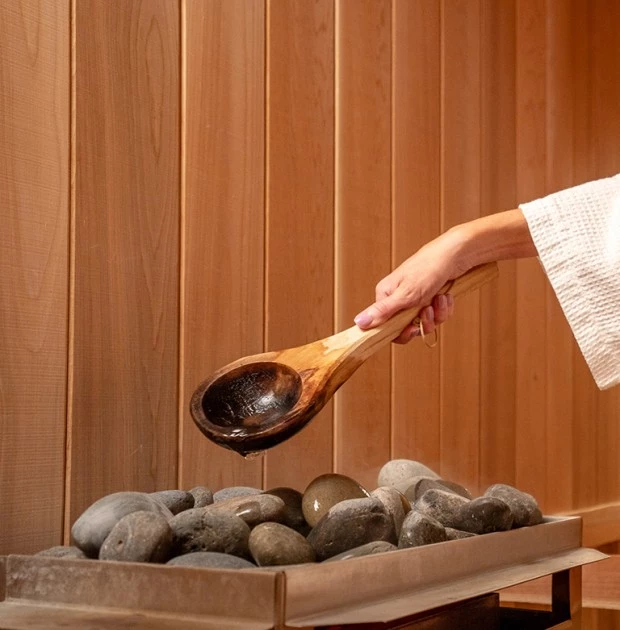 a person pouring water into a wooden spoon