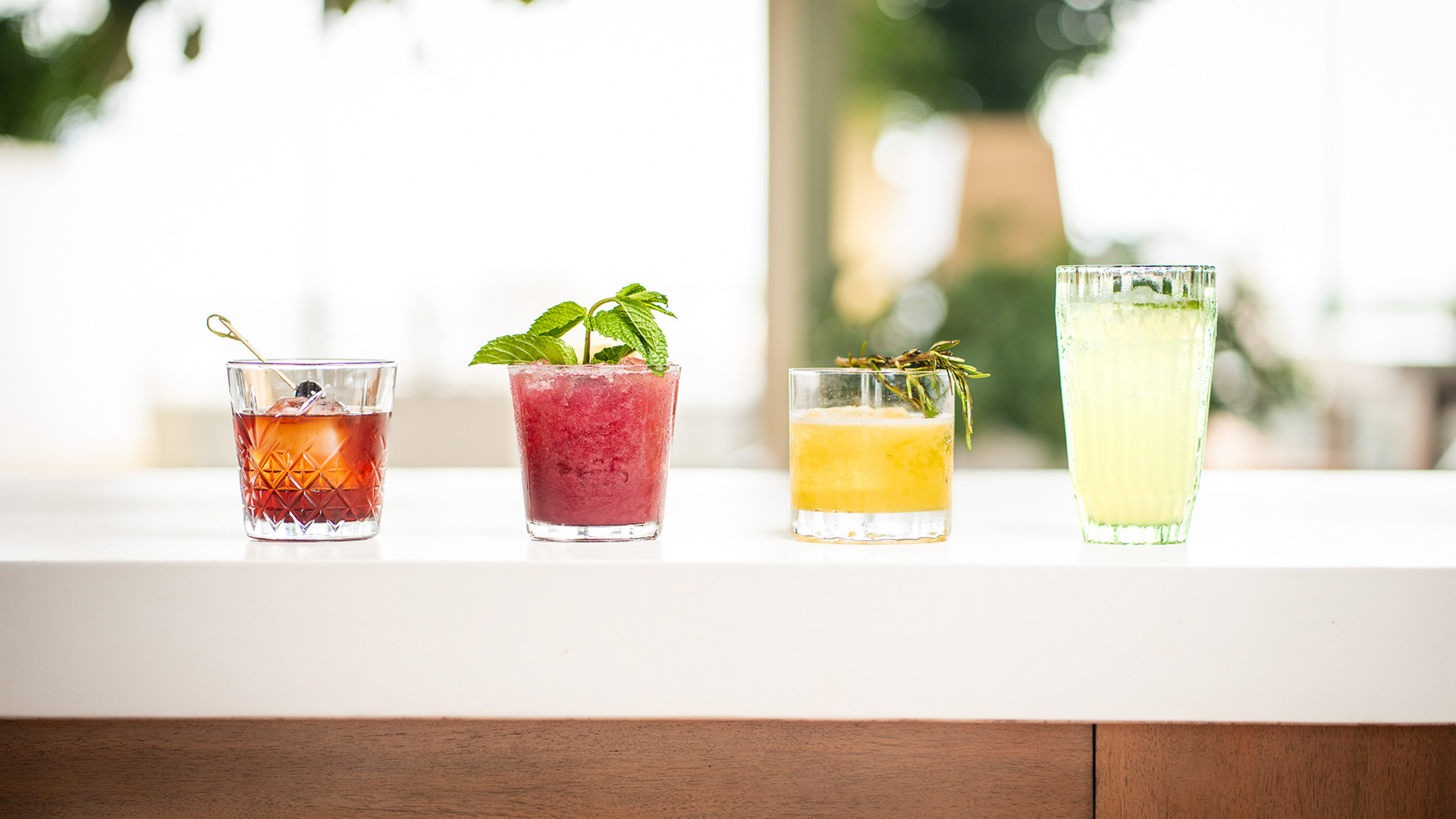 a row of glasses with different drinks on a table