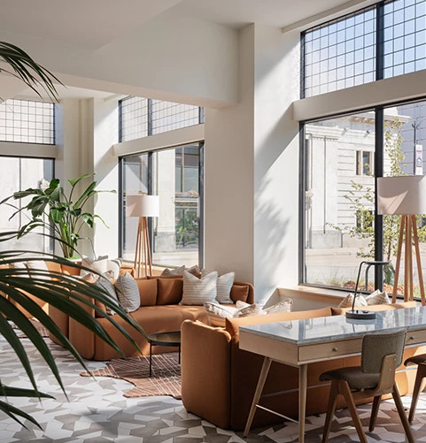 a room with a couch and a table with a plant in it