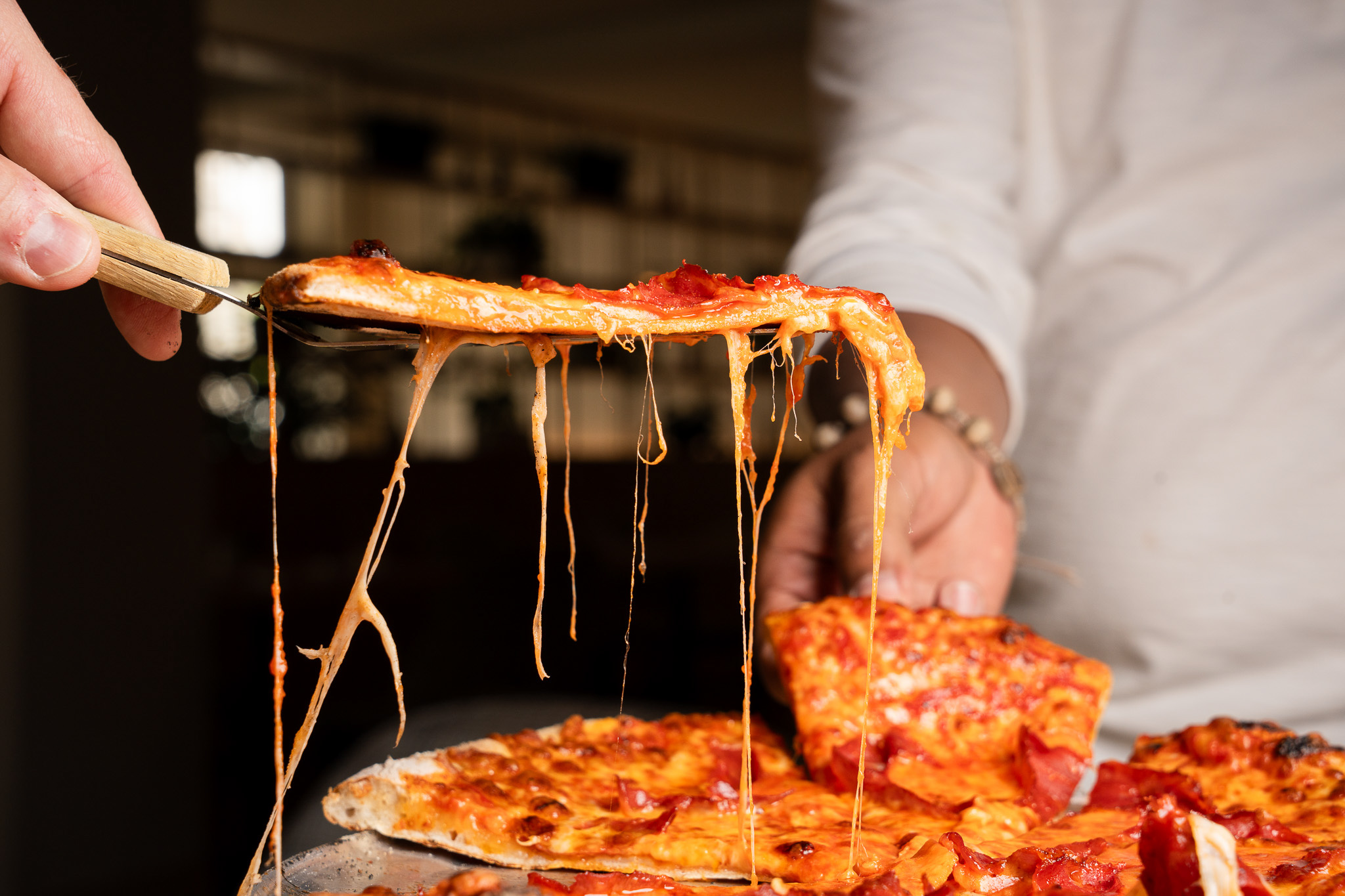 a person holding a slice of pizza