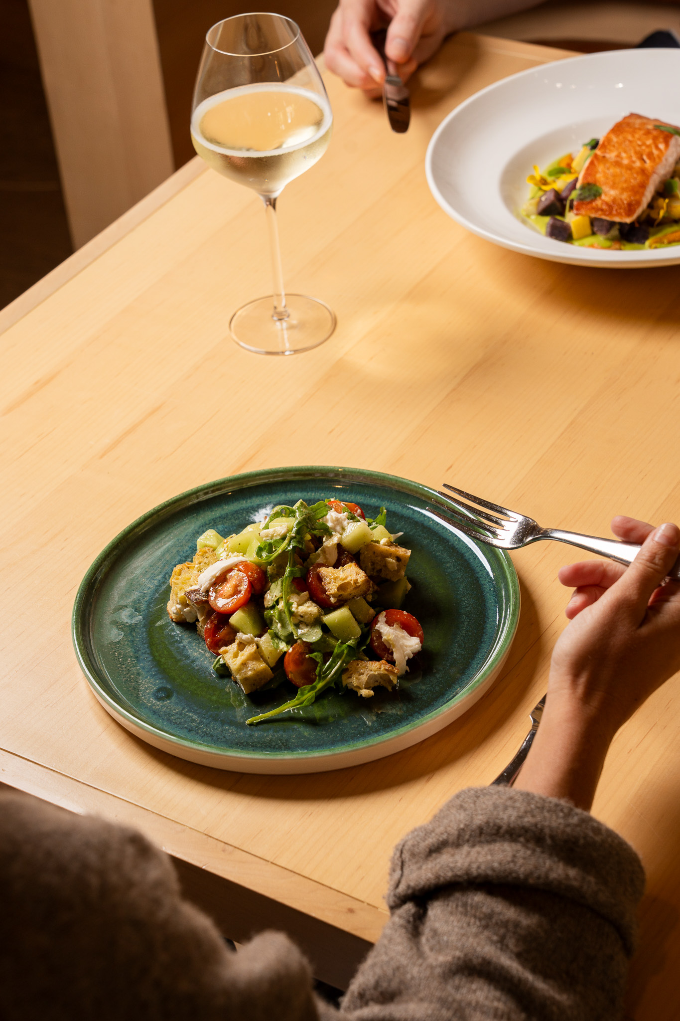 a plate of salad and a glass of wine