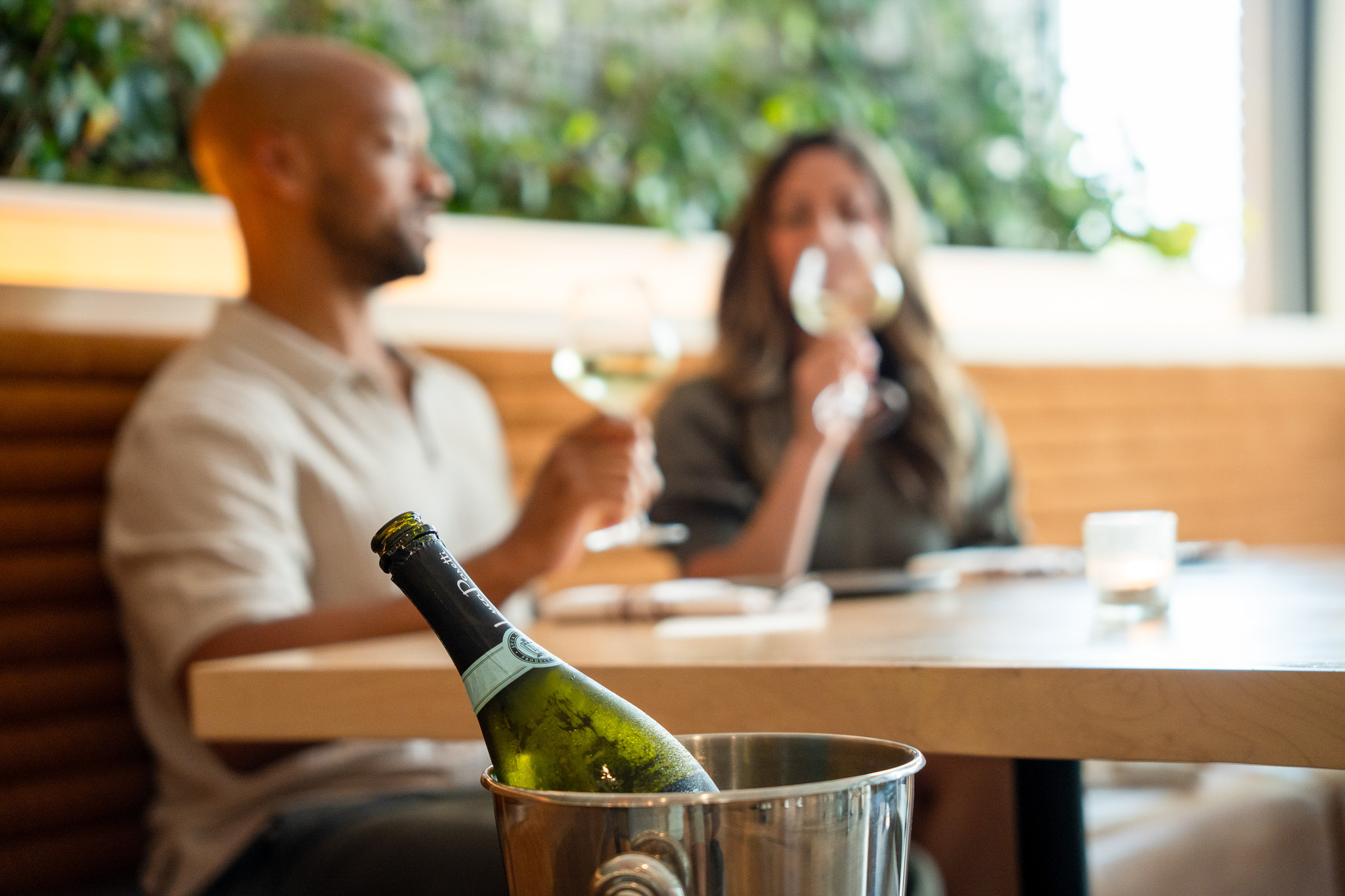 a bottle in a bucket with a man and woman in the background
