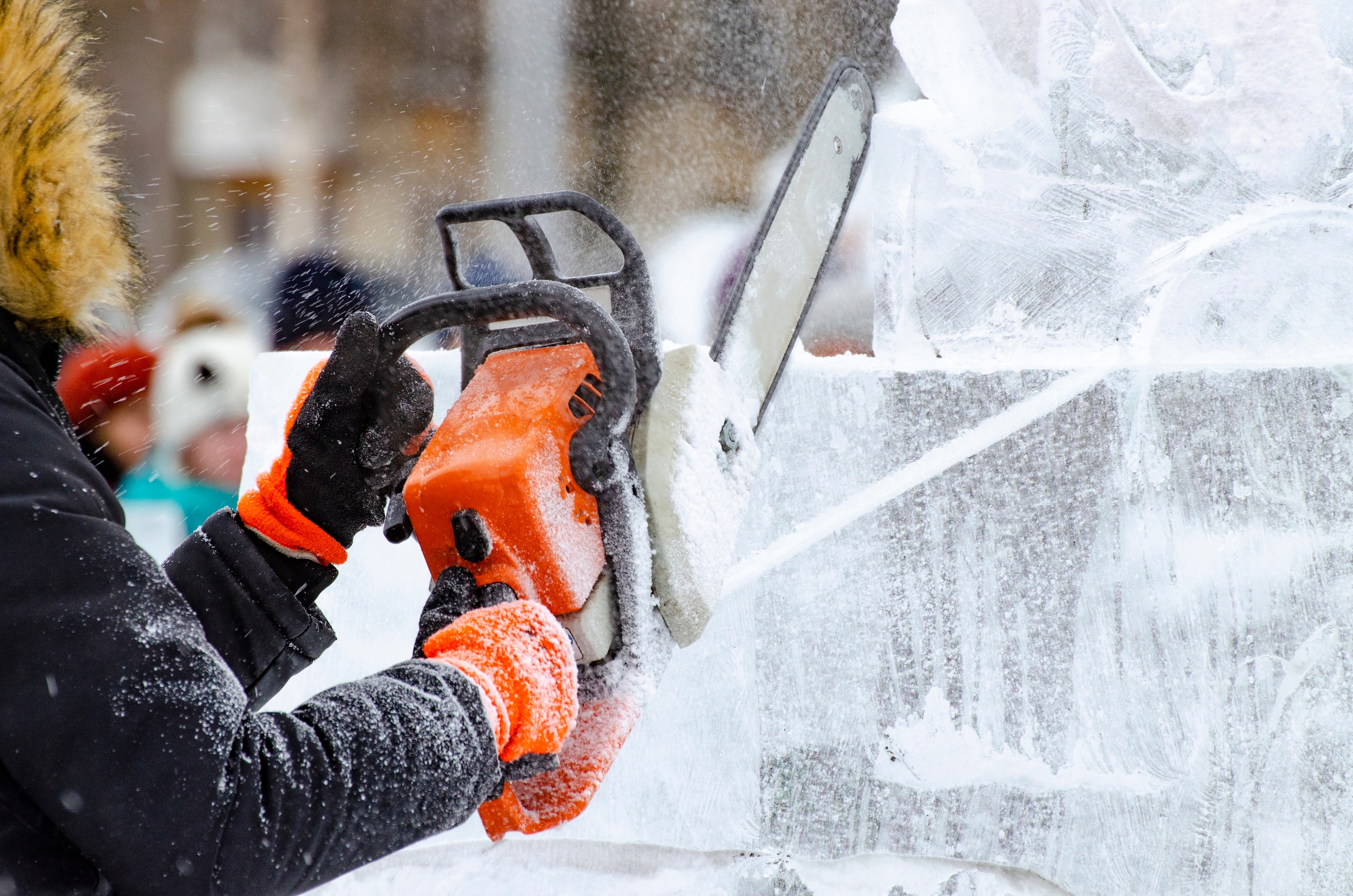 a person using a chainsaw to cut ice