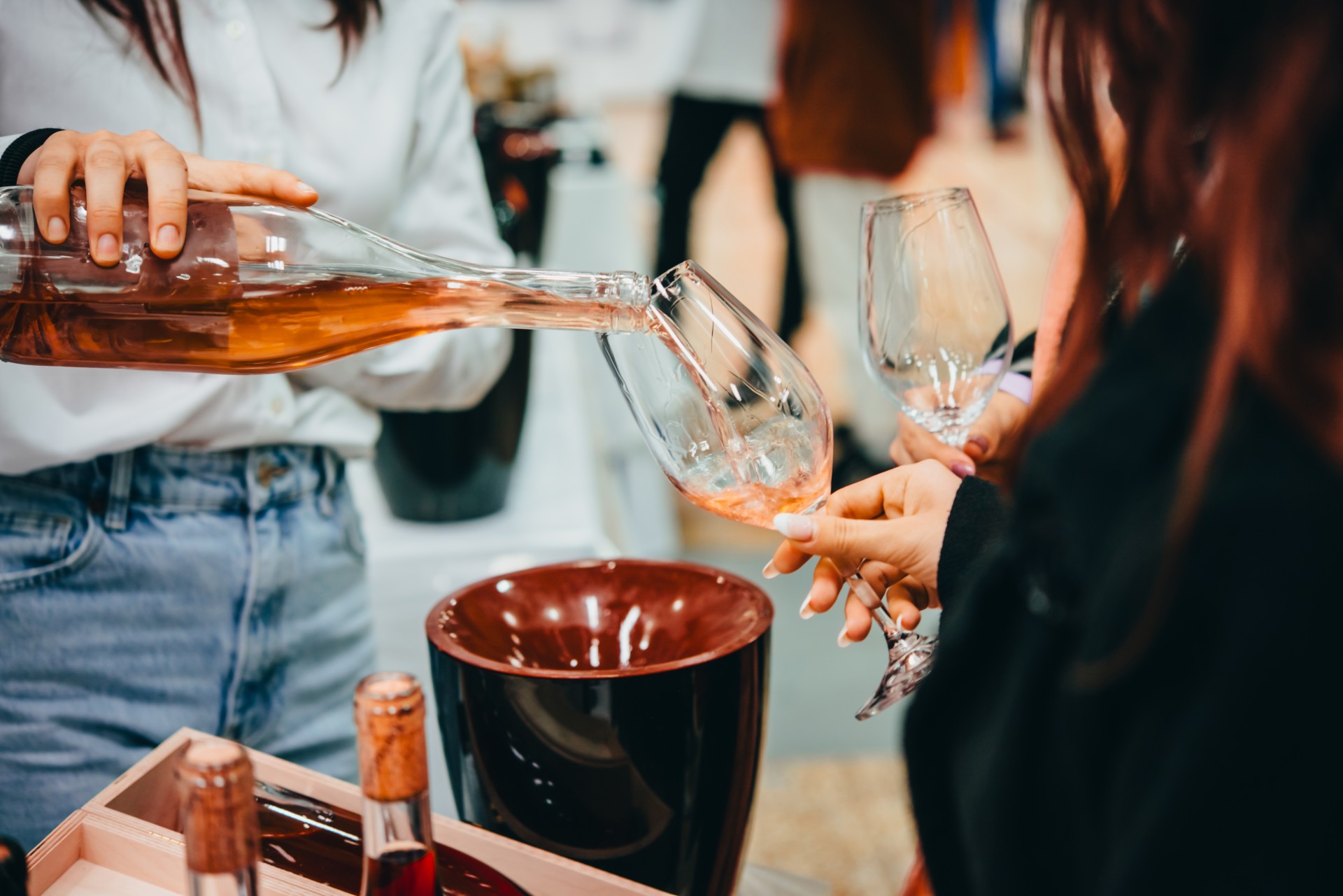 a person pouring wine into a glass