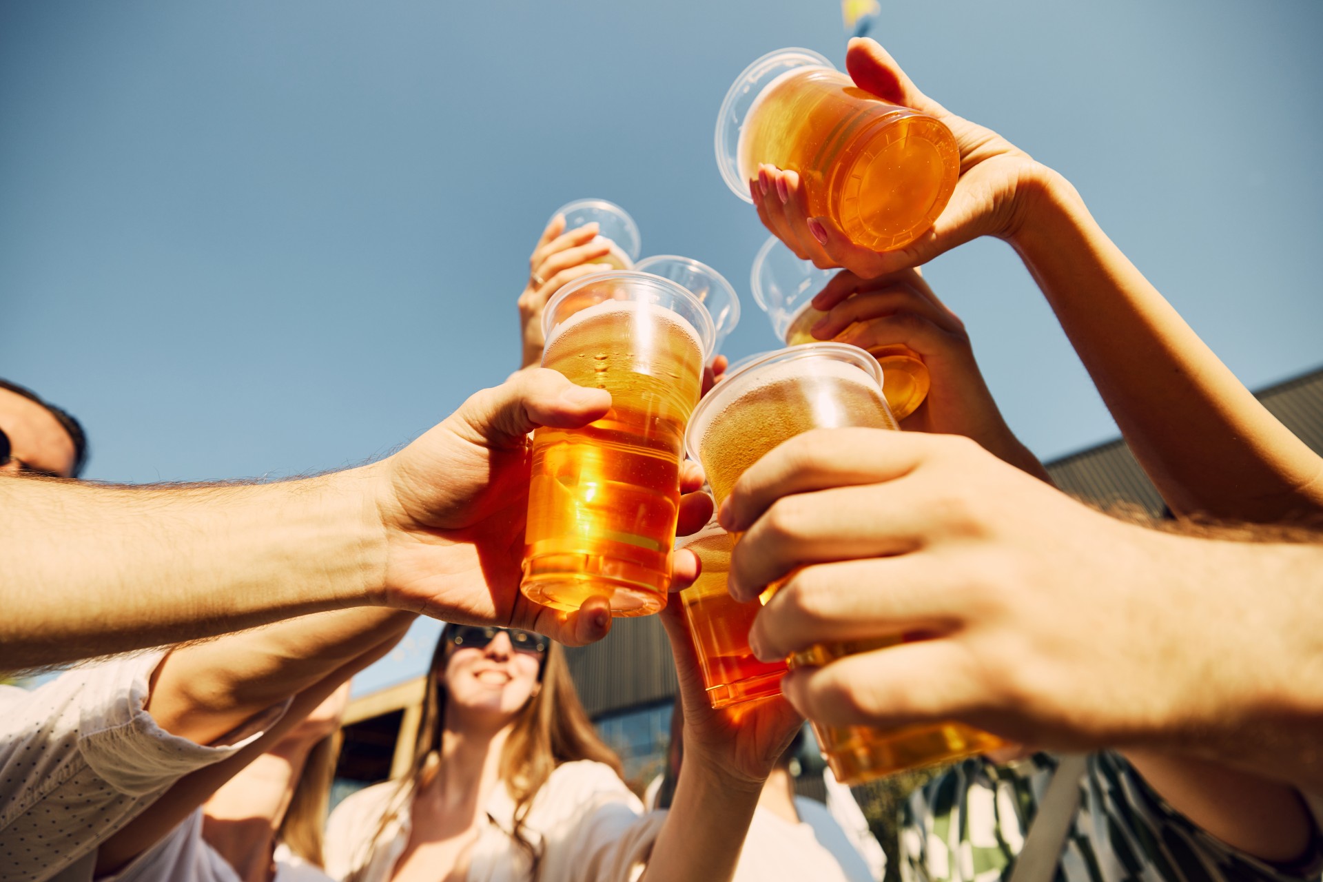 a group of people holding plastic cups with liquid in them