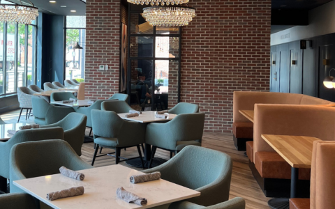 a room with a brick wall and tables and chairs