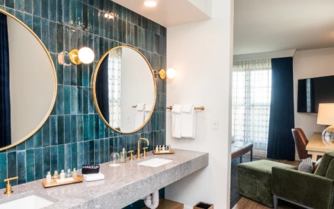 a bathroom with a marble countertop sink and a green chair