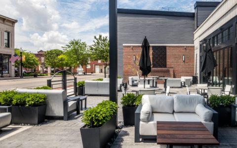 a patio with white furniture and plants