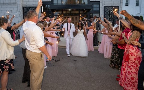 a group of people holding sparklers and walking down the street